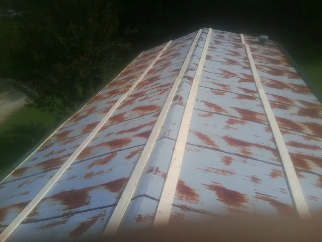 Rusted metal roof panels with new wood purlins before replacement — Storm Damage Roof Repair in Erin by Roofing Brothers